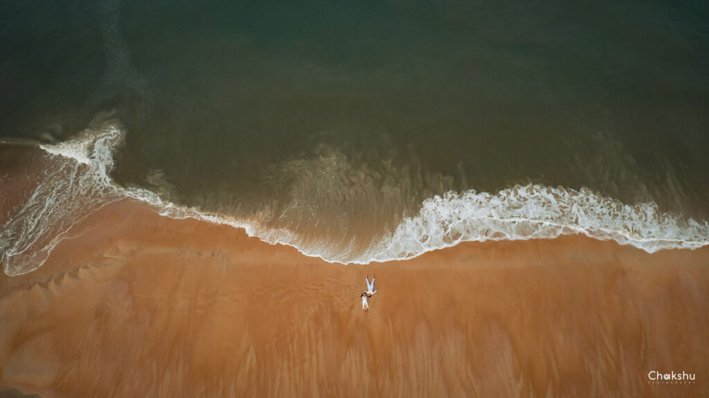 Aerial view of an individual strolling along the beach, capturing a serene moment for a pre-wedding photographer in Delhi.