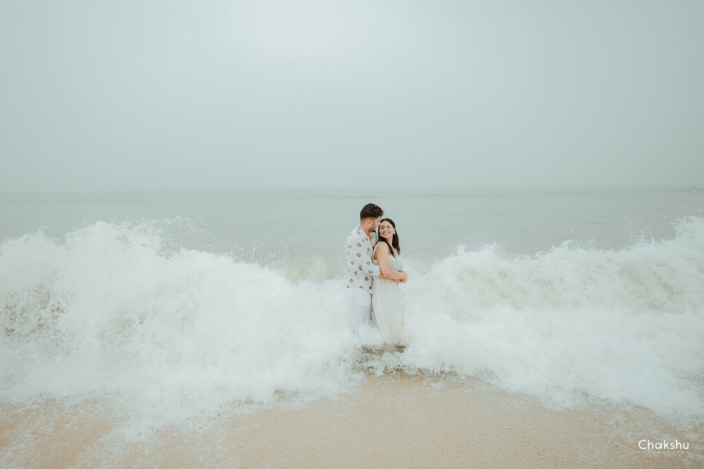 A couple enjoying a romantic moment on the beach, captured by a pre-wedding photographer in Delhi.