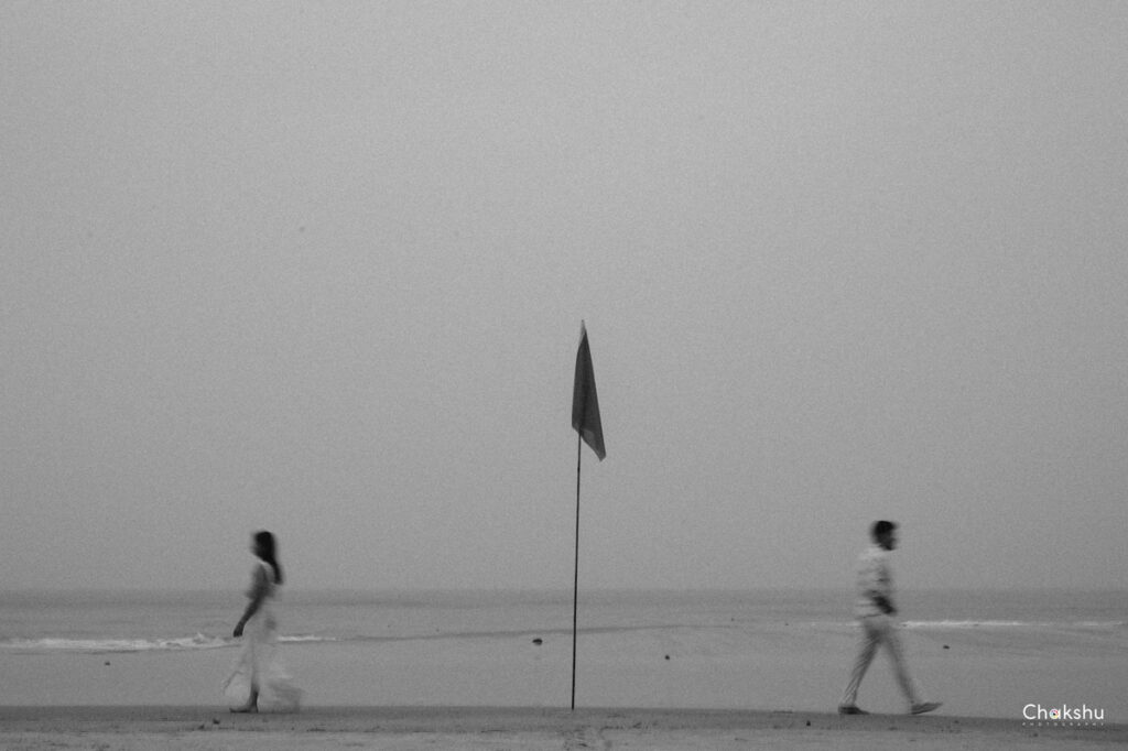 A couple walks hand in hand on the beach, embodying love and joy, ideal for a pre-wedding photographer in Delhi.