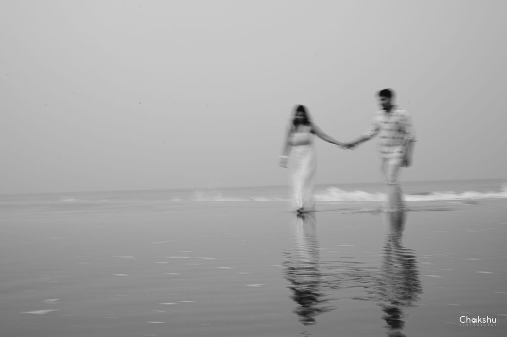 A couple strolls hand in hand along the beach, capturing a romantic moment perfect for a pre-wedding photographer in Delhi.