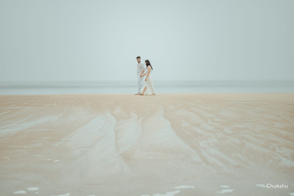 A couple strolls along the beach, capturing a romantic moment, showcasing the work of a pre-wedding photographer in Delhi.