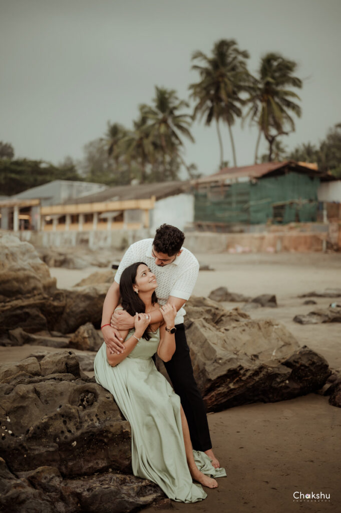 A beautiful couple a girl sitting on a rock and a boy standing out with her image captured by best pre-wedding photographer in delhi.