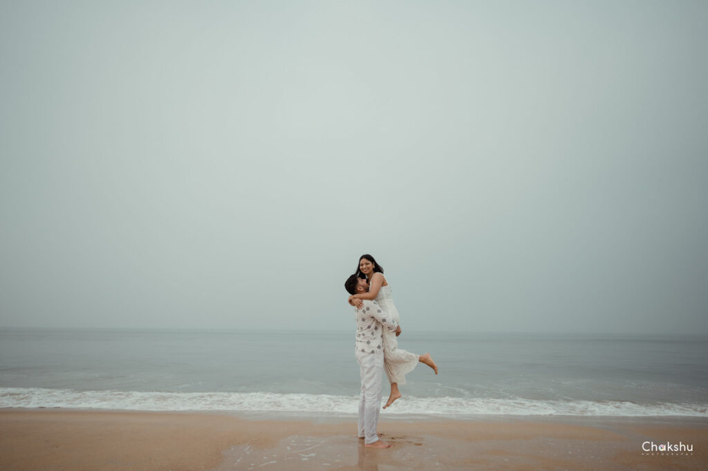 A couple enjoying a romantic moment on the beach, captured by a pre-wedding photographer in Delhi.