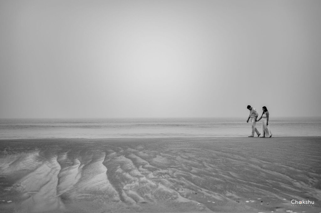 In a foggy beach setting, a bride and groom embrace, showcasing love as captured by a pre-wedding photographer in Delhi.